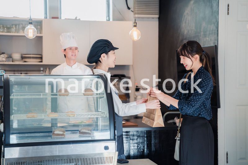 こだわりのお店でテイクアウトをする若い女性