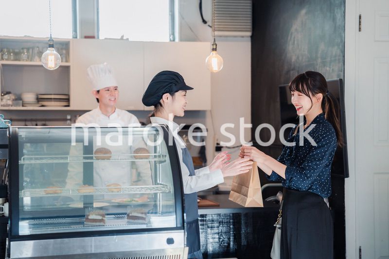 こだわりのお店でテイクアウトをする若い女性