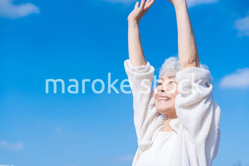 外で伸びをするシニアの女性