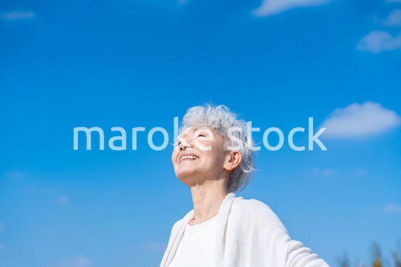 外で深呼吸するシニアの女性