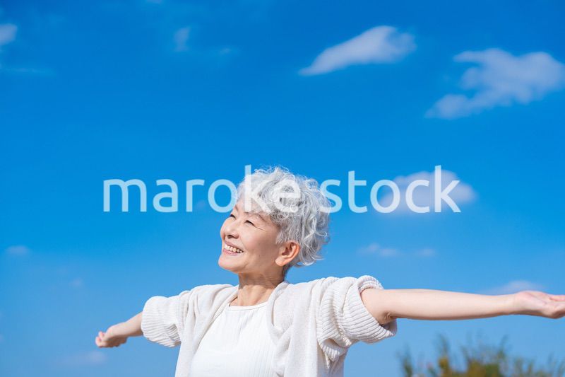 外で深呼吸するシニアの女性