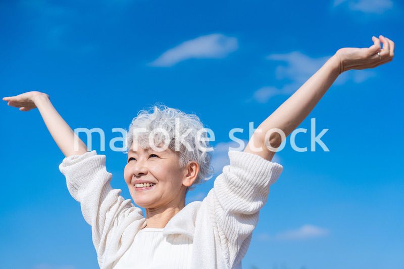 外で深呼吸するシニアの女性