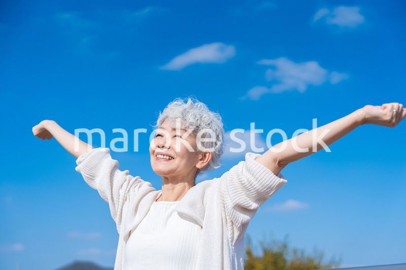 外で深呼吸するシニアの女性