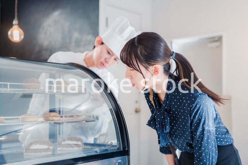 お店でスイーツを選ぶ若い女性