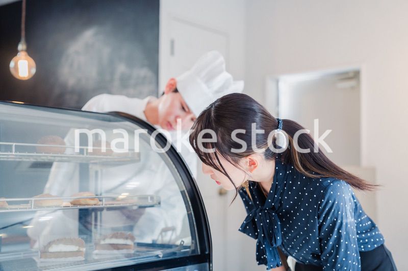 お店でスイーツを選ぶ若い女性