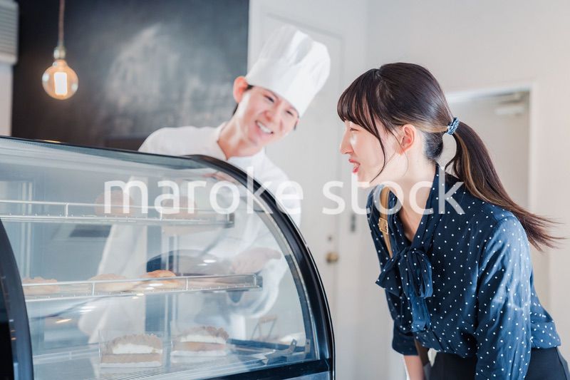 お店でスイーツを選ぶ若い女性