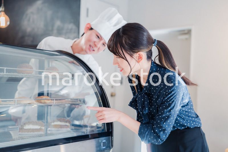 お店でスイーツを選ぶ若い女性