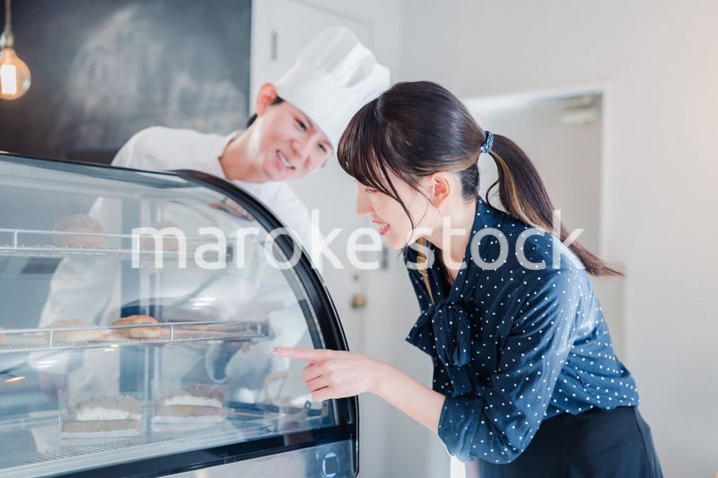 お店でスイーツを選ぶ若い女性