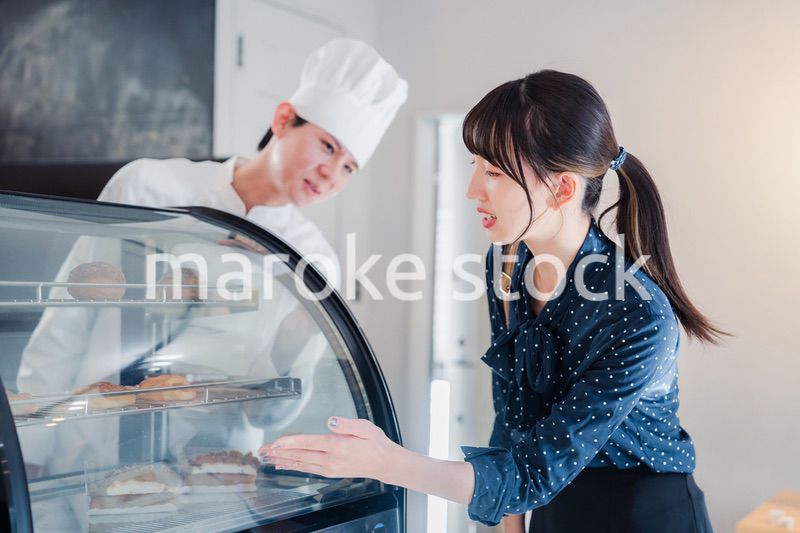 お店でスイーツを選ぶ若い女性