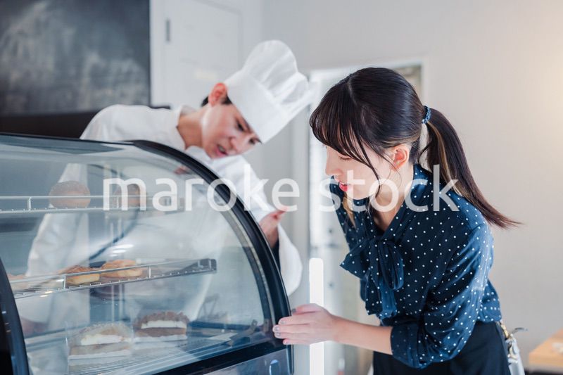 お店でスイーツを選ぶ若い女性