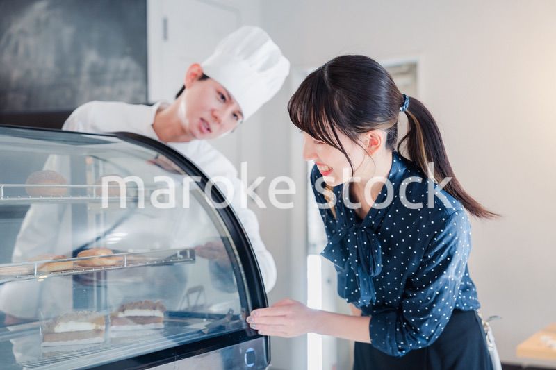 お店でスイーツを選ぶ若い女性