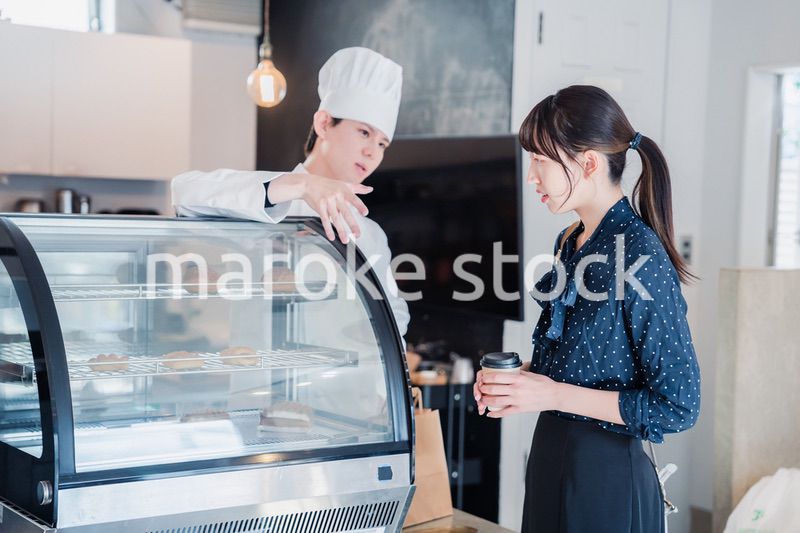 お店でスイーツを選ぶ若い女性