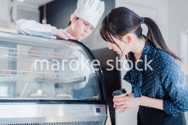 お店でスイーツを選ぶ若い女性