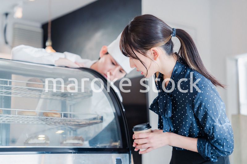 お店でスイーツを選ぶ若い女性