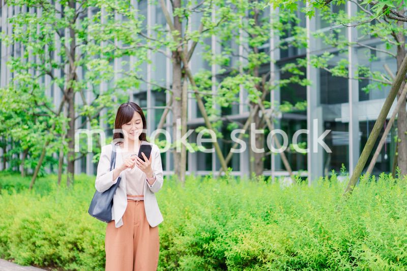 歩きスマホをするビジネスウーマン