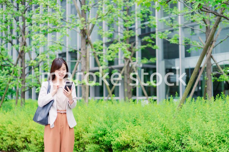 歩きスマホをするビジネスウーマン