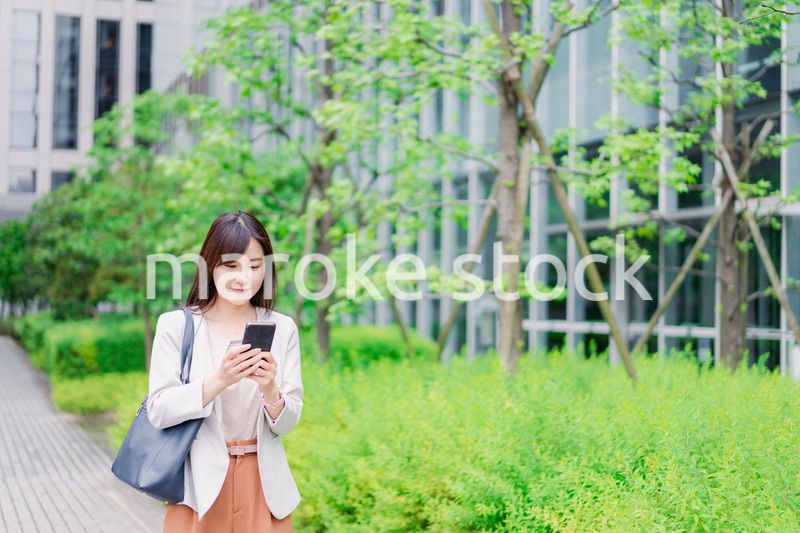 歩きスマホをするビジネスウーマン