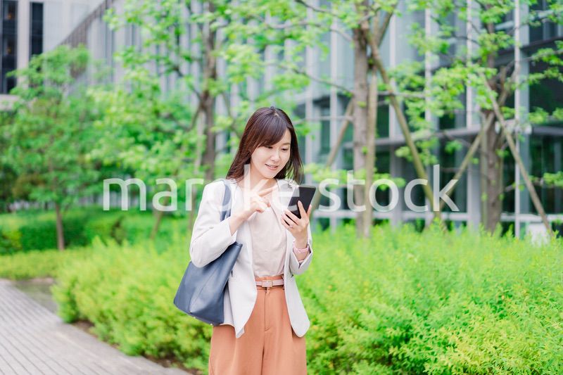 歩きスマホをするビジネスウーマン