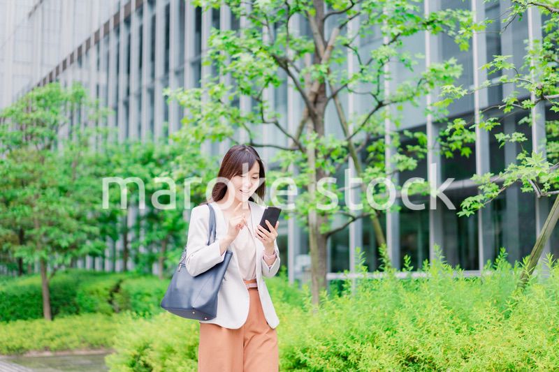歩きスマホをするビジネスウーマン