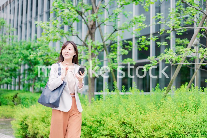 歩きスマホをするビジネスウーマン