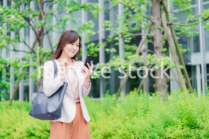 歩きスマホをするビジネスウーマン