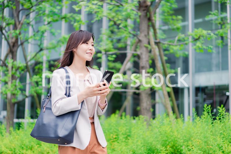 歩きスマホをするビジネスウーマン