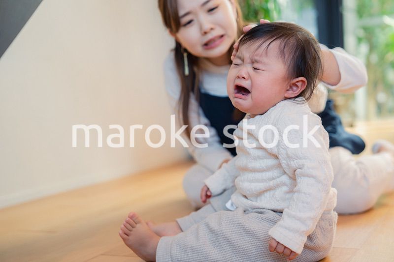 泣きわめく赤ちゃんをあやすベビーシッター