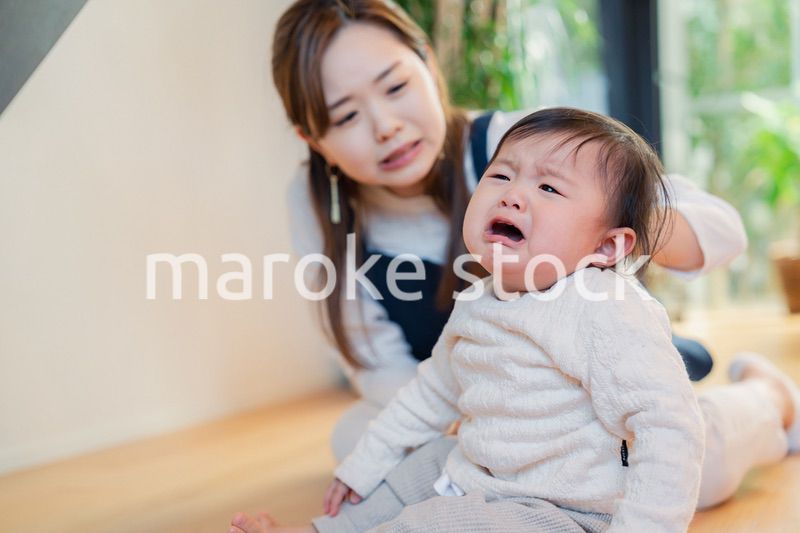 泣きわめく赤ちゃんをあやすベビーシッター