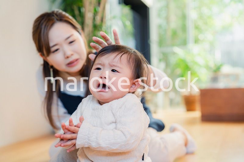 泣きわめく赤ちゃんをあやすベビーシッター