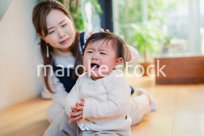 泣きわめく赤ちゃんをあやすベビーシッター