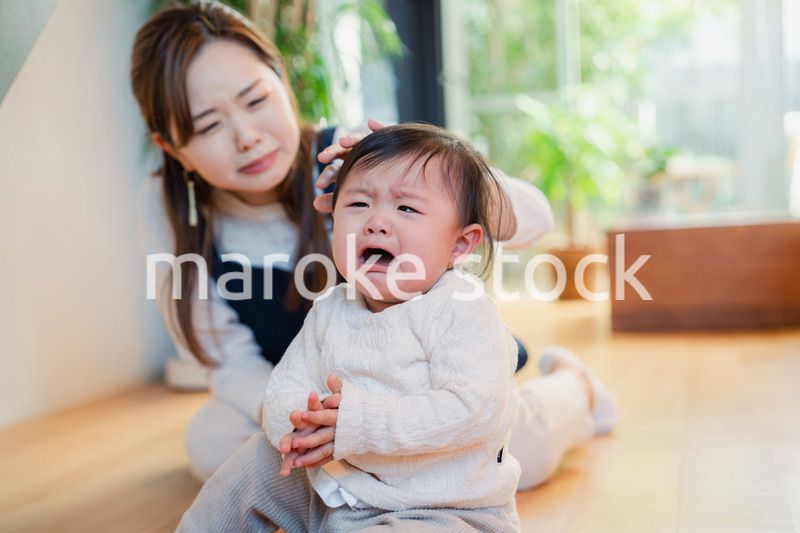 泣きわめく赤ちゃんをあやすベビーシッター