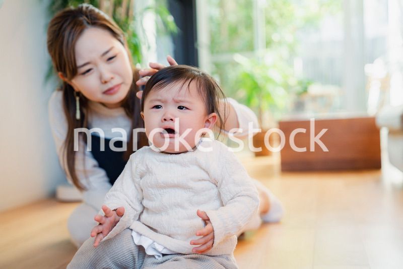 泣きわめく赤ちゃんをあやすベビーシッター