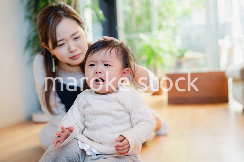 泣きわめく赤ちゃんをあやすベビーシッター