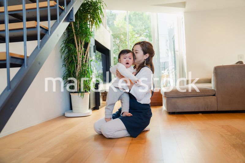 泣きわめく赤ちゃんをあやすベビーシッター