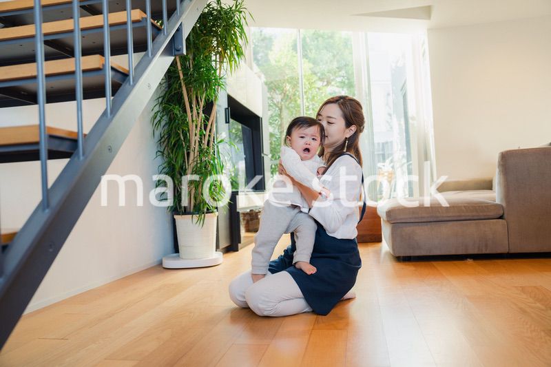 泣きわめく赤ちゃんをあやすベビーシッター