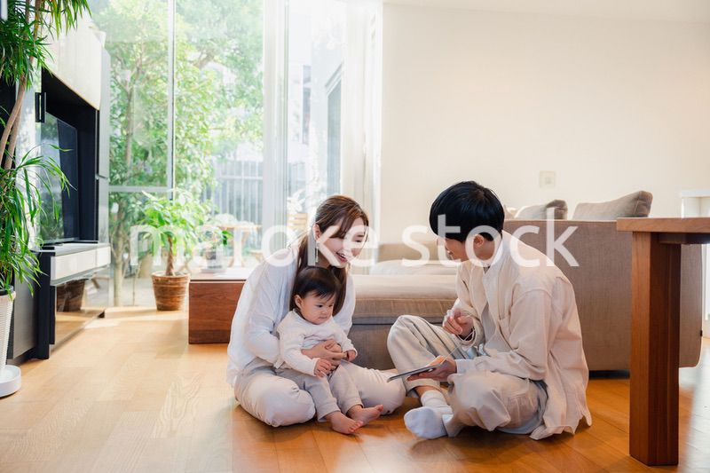 赤ちゃんに絵本の読み聞かせをする両親