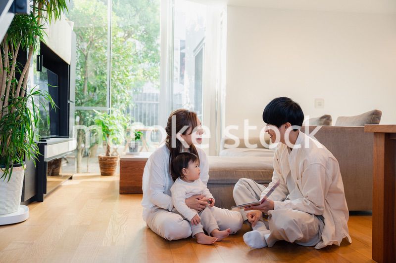 赤ちゃんに絵本の読み聞かせをする両親