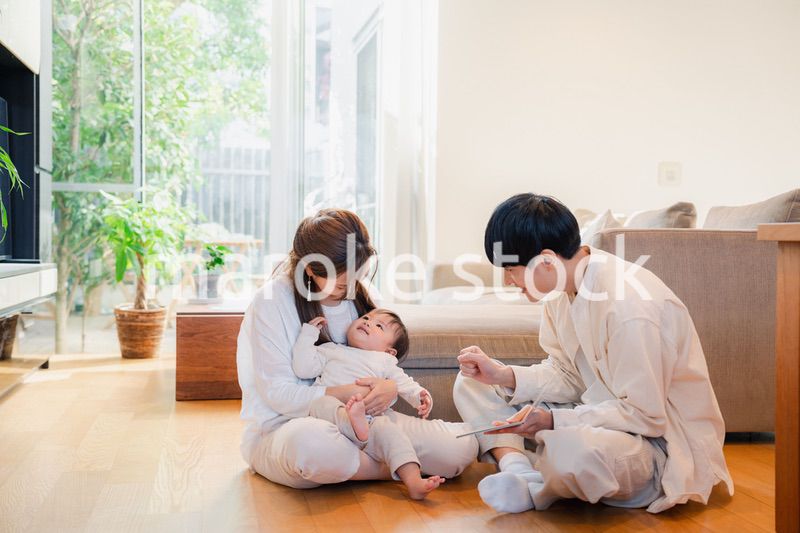 赤ちゃんに絵本の読み聞かせをする両親