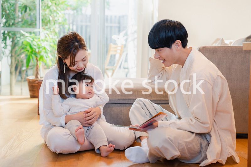 赤ちゃんに絵本の読み聞かせをする両親