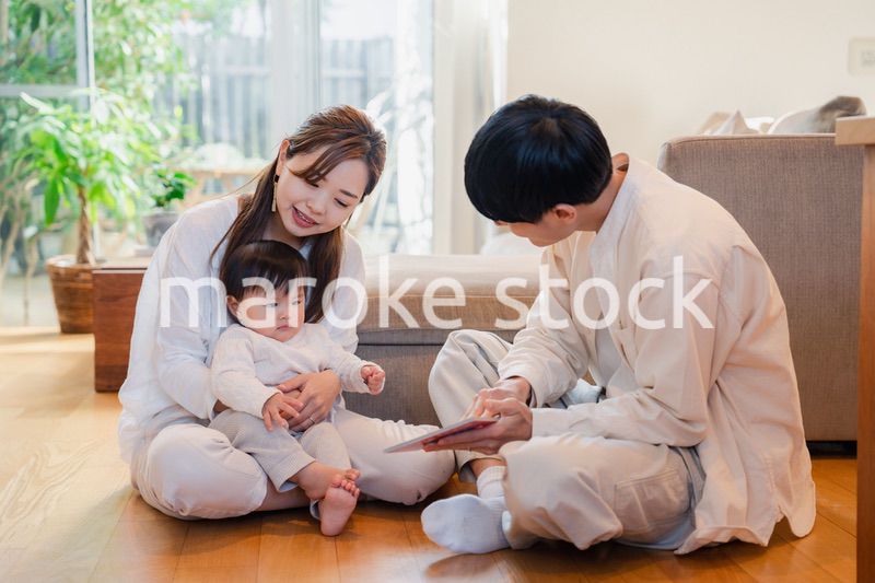 赤ちゃんに絵本の読み聞かせをする両親