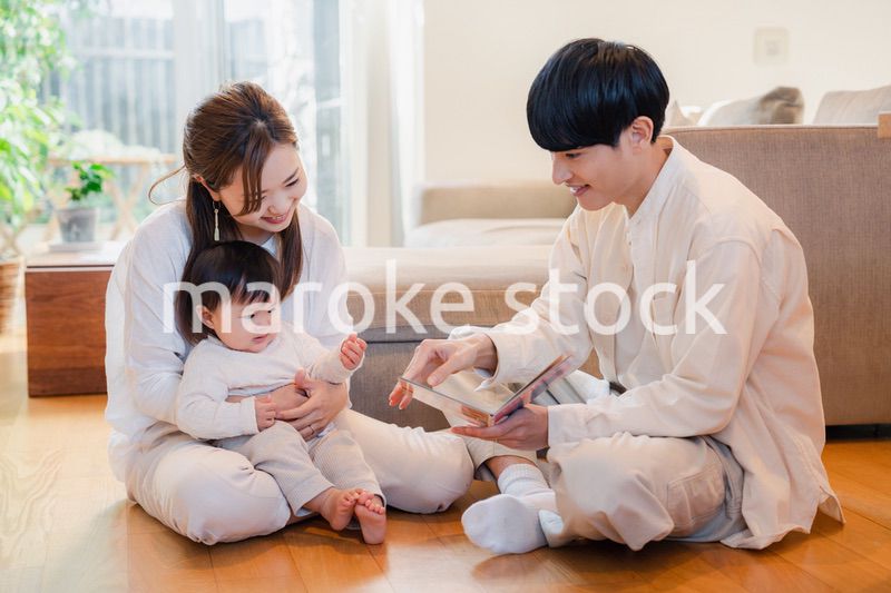 赤ちゃんに絵本の読み聞かせをする両親