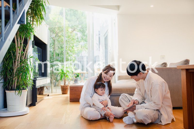 赤ちゃんに絵本の読み聞かせをする両親