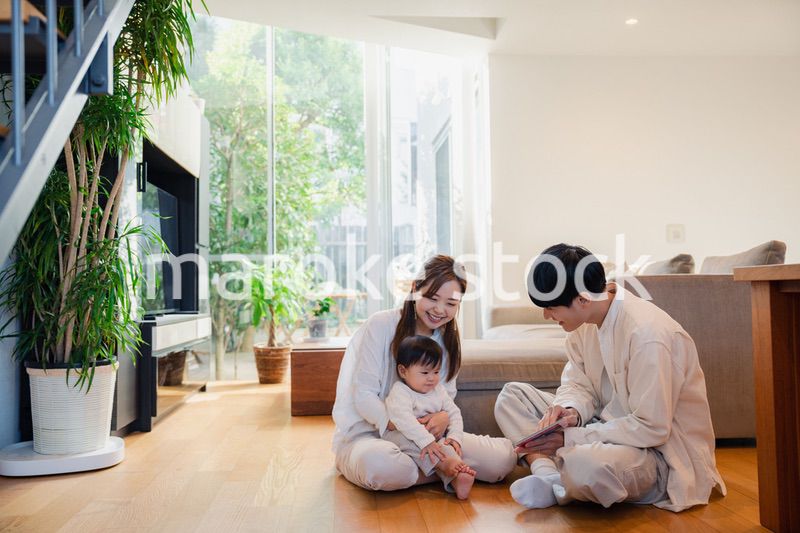 赤ちゃんに絵本の読み聞かせをする両親