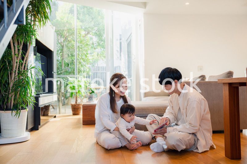 赤ちゃんに絵本の読み聞かせをする両親