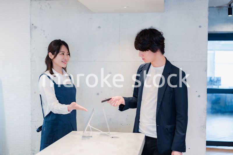 カフェでクレジットカード決済をする男性