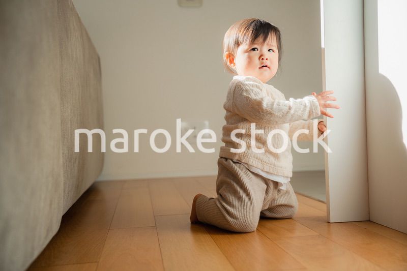 家でつかまり立ちをする赤ちゃん