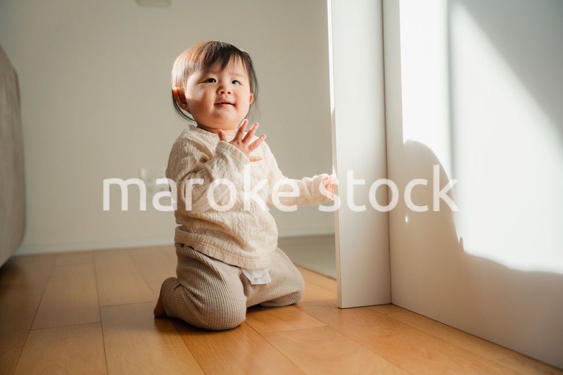 家でつかまり立ちをする赤ちゃん