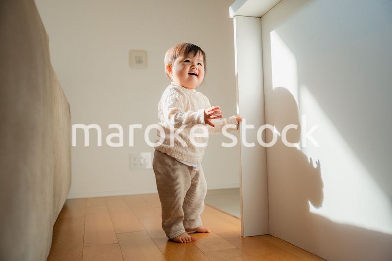 家でつかまり立ちをする赤ちゃん
