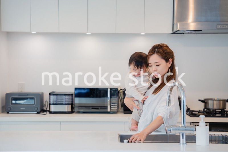 赤ちゃんを抱っこしながら家事をするお母さん