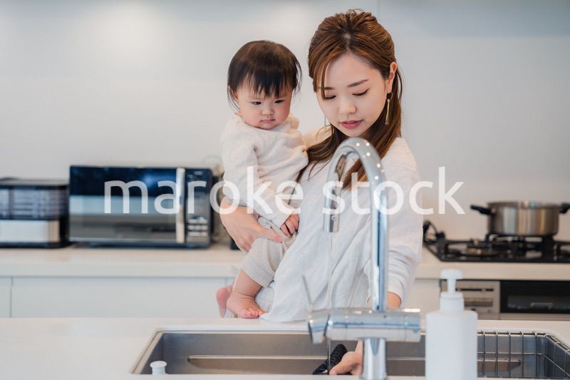 赤ちゃんを抱っこしながら家事をするお母さん